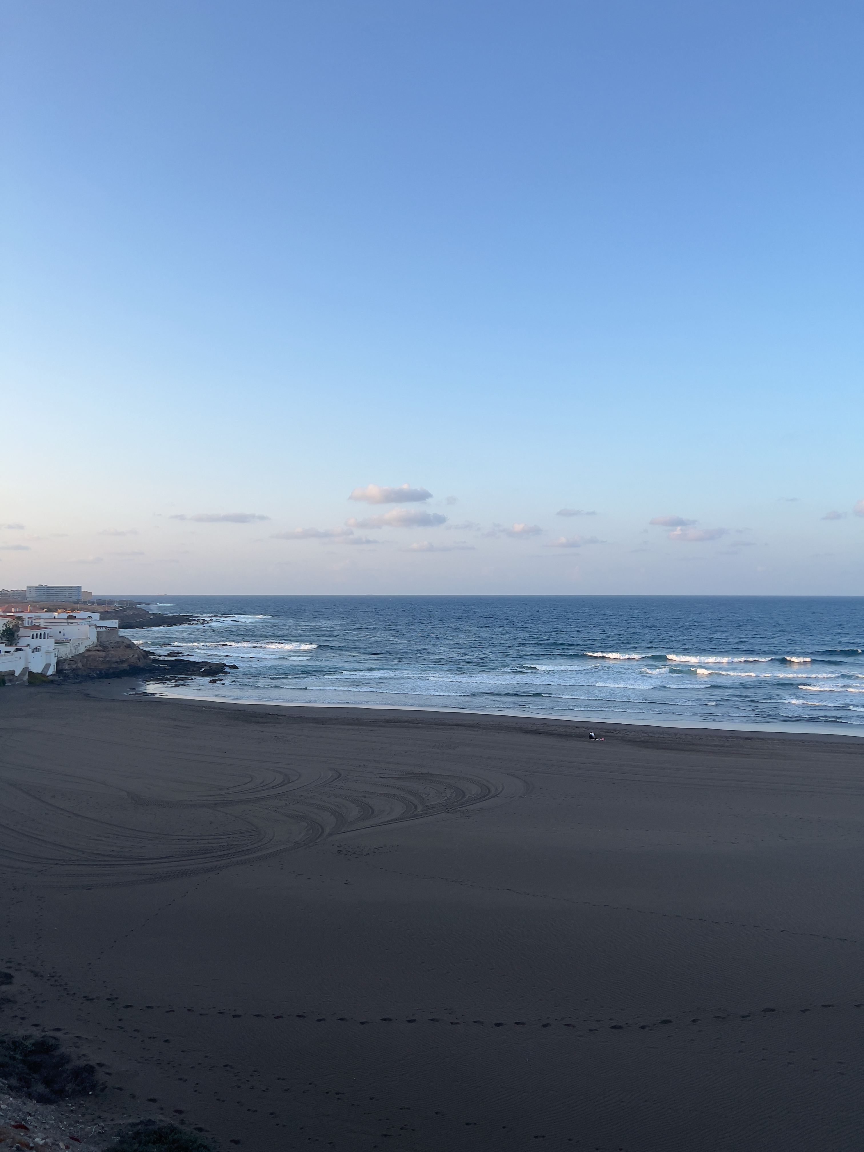 Playa del Hombre beach in Gran Canaria, featuring a sandy shoreline with surfable water conditions