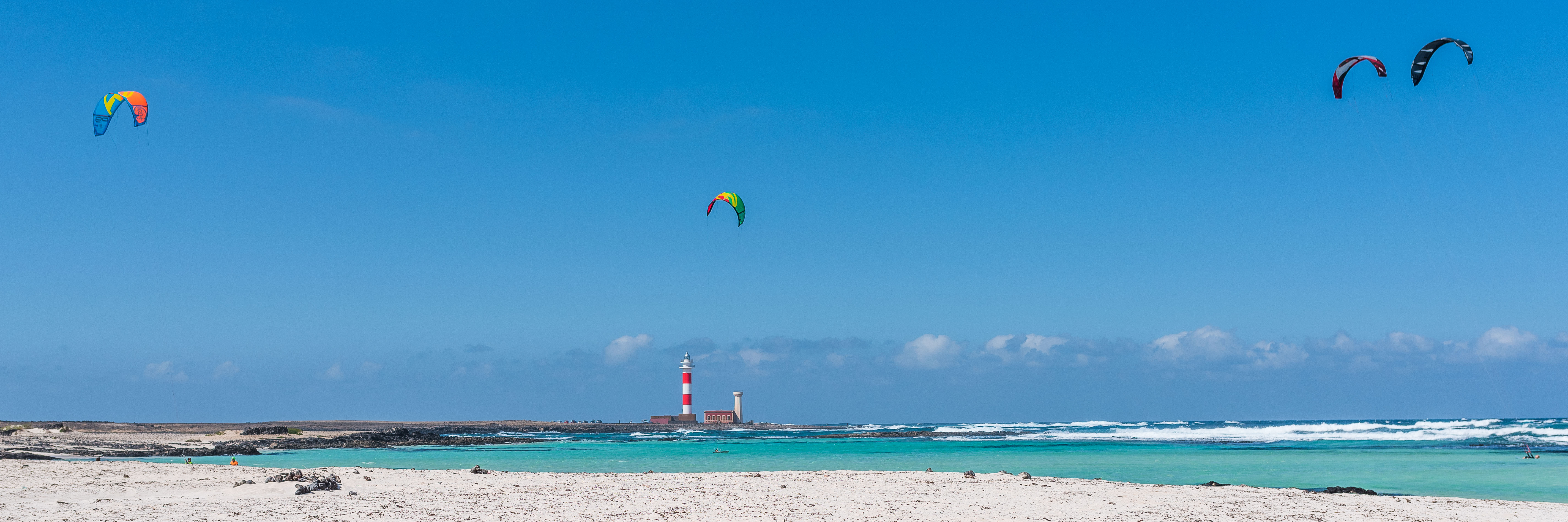 Caleta del Marrajo beach in Fuerteventura, featuring a sandy shoreline with moderate water conditions