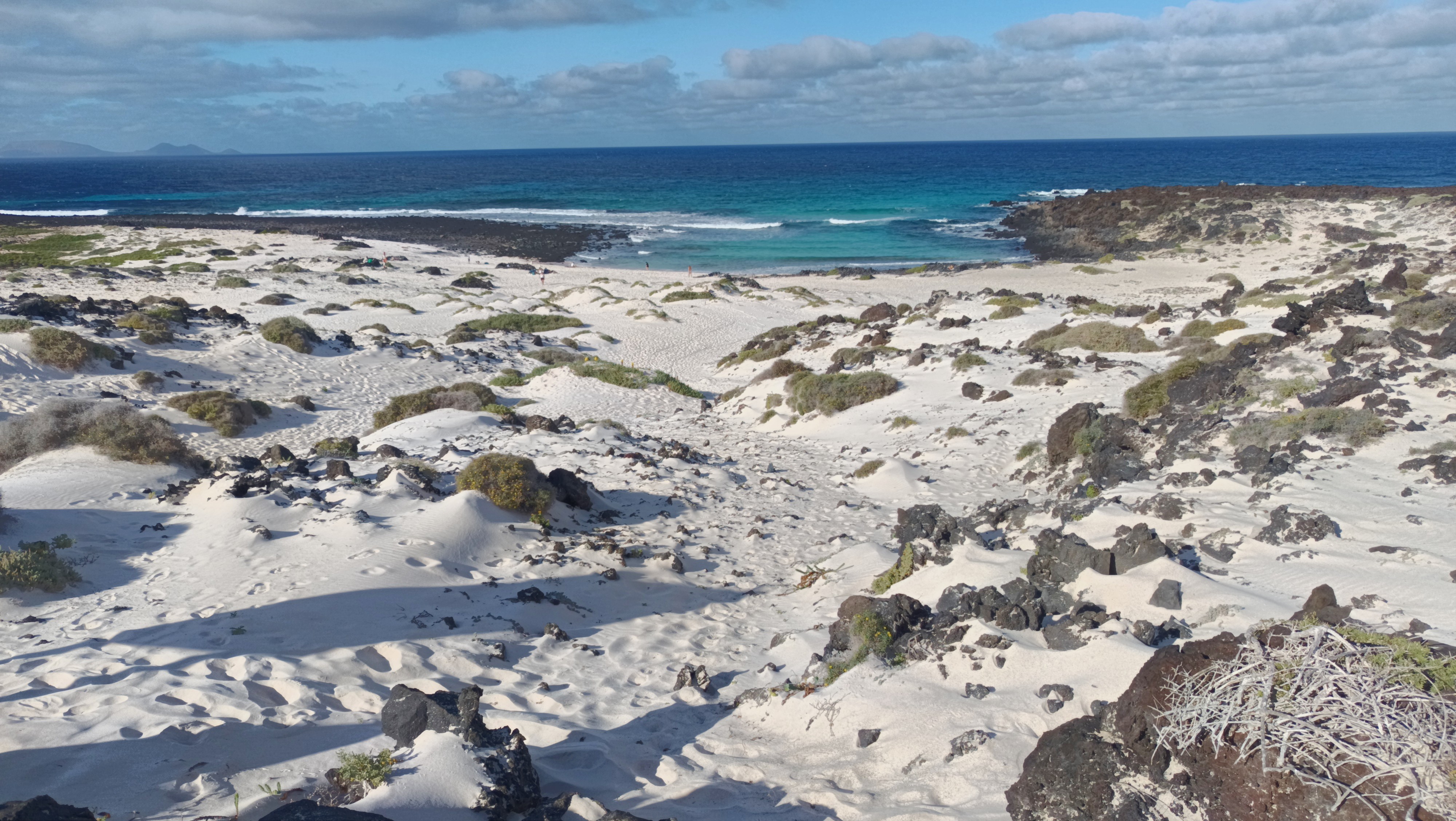 Caleta del Mojon Blanco beach in Lanzarote, featuring a sandy shoreline with moderate water conditions